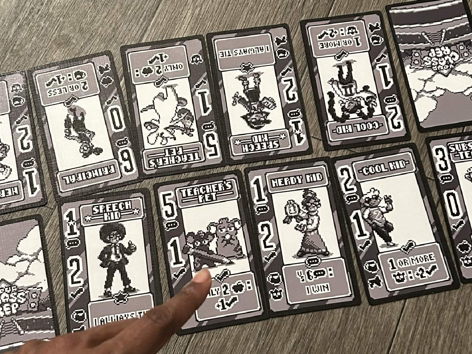 A close-up of a player tallying votes with Your Class Rep cards.
